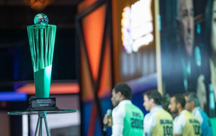 The Entrepreneurship World Cup trophy on stage at the global finals, with Global 100 finalists in the background