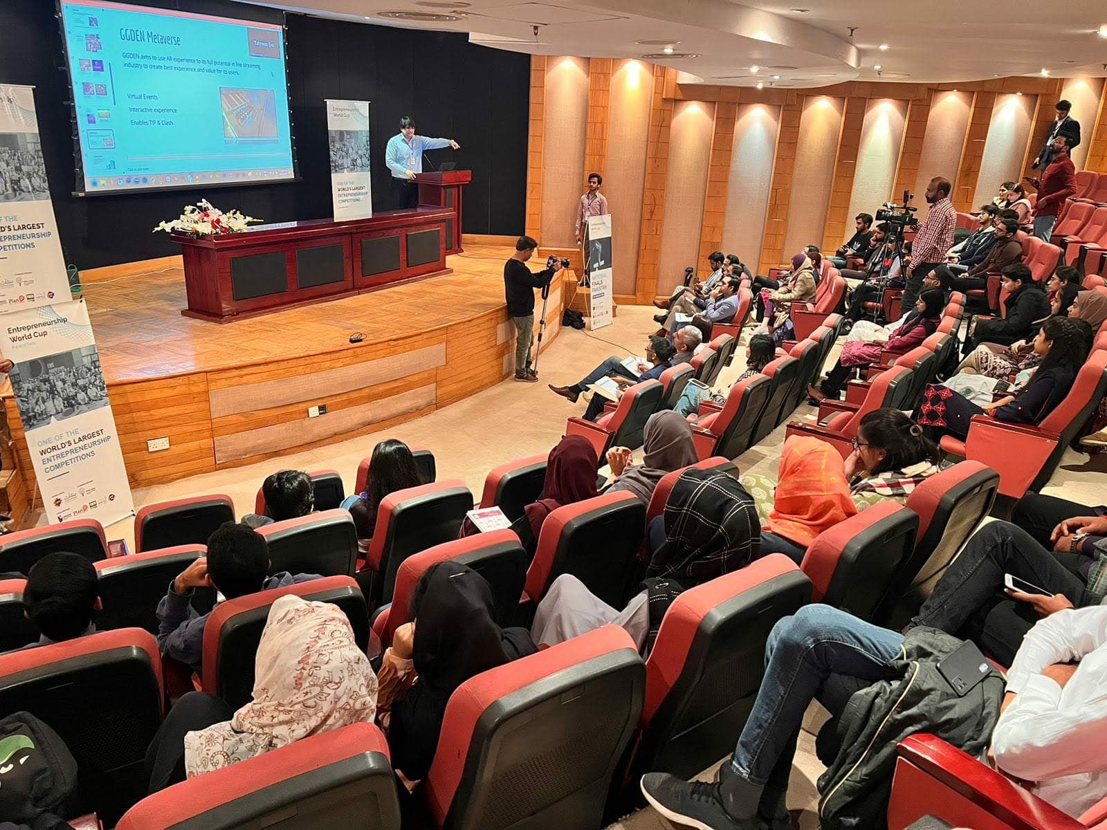 A packed session at an Entrepreneurship World Cup Pakistan event — a founder pitching on stage to a full auditorium
