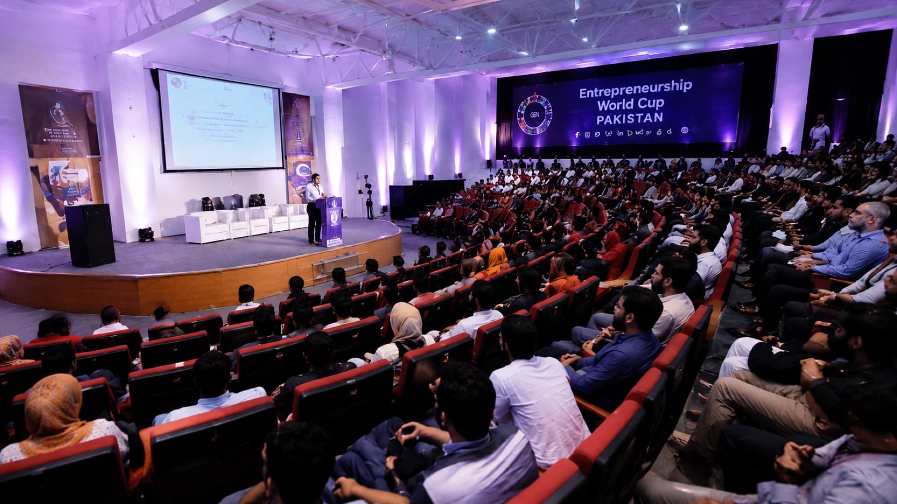 A packed session at an Entrepreneurship World Cup Pakistan event — a speaker on the main stage before a full auditorium under the GEN backdrop